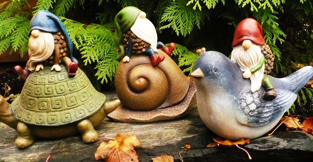 decoración de gnomos de jardín montados encima de animales como tortugas, caracoles o palomas